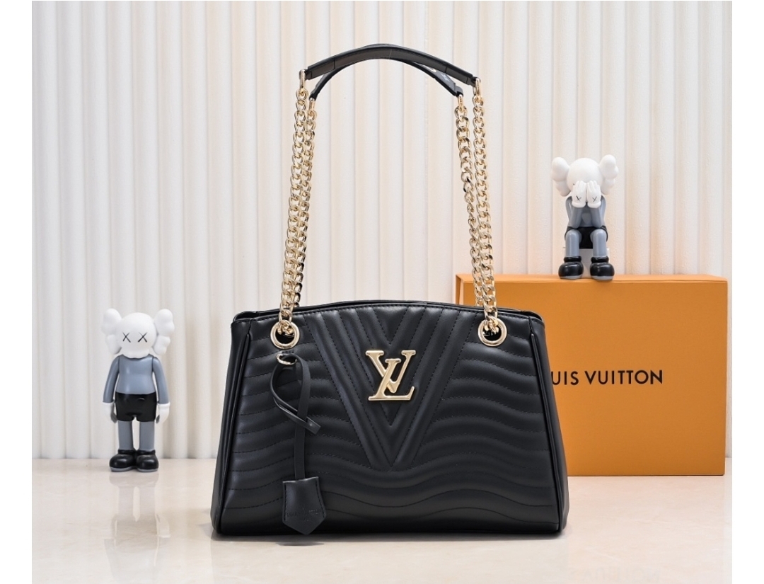 Black quilted handbag with gold chain straps and front logo detail, displayed on a clean surface with decorative background.